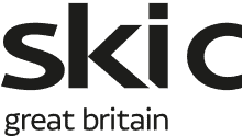 Snow-covered ski slopes with winter sports enthusiasts enjoying skiing and snowboarding in bright winter conditions.