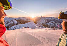 Scenic winter landscape in Carinthia, Austria with snow-covered mountains at sunrise, perfect for skiing and family holidays.